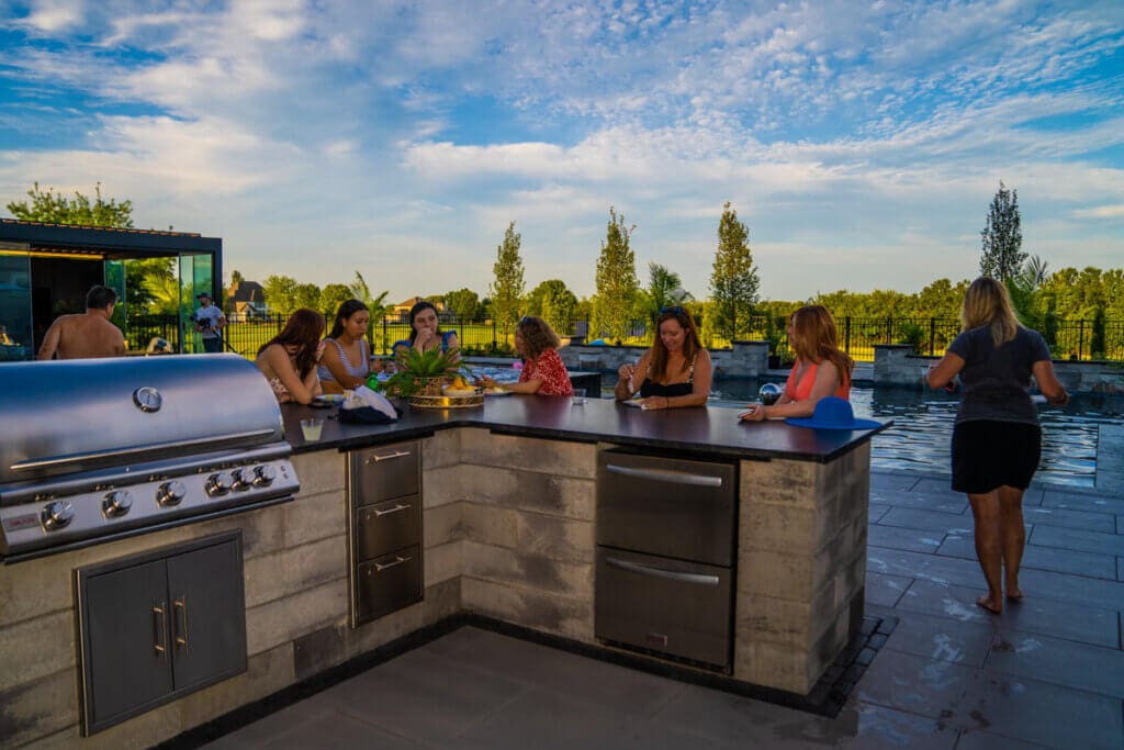 Example of a stone outdoor kitchen being enjoyed at a party
